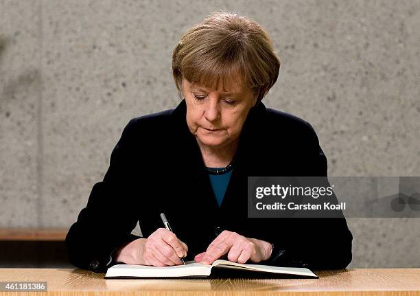 German Chancellor Angela Merkel signs a condolence book in the French Embassy on January 8, 2015 in Berlin, Germany. Twelve people were killed...