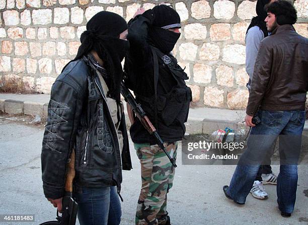 Two men hold their rifles during clashes between the Free Syrian Army and the Islamic State of Syria and Al-Sham on January 4, 2014 in Aleppo, Syria.