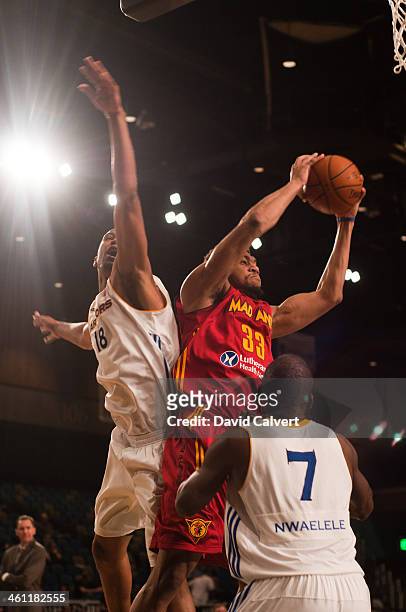 Tony Mitchell of the Fort Wayne Mad Ants pulls down a rebound away from Dominic McGuire and Daniel Nwaelele of the Santa Cruz Warriors during the...