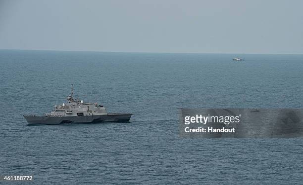 The littoral combat ship USS Fort Worth , with its 11-meter rigid-hull inflatable boat trailing behind, conducts visual and subsurface searches on...