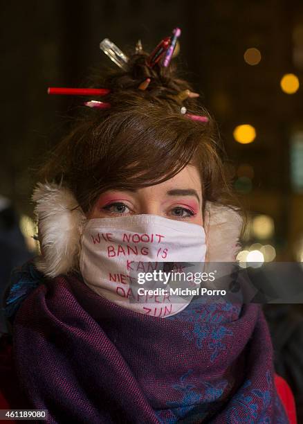 Woman wears a mask stating: 'He who never feels fear, cannot be brave' at Dam Square in support of the victims of the terrorist attack in Paris on...