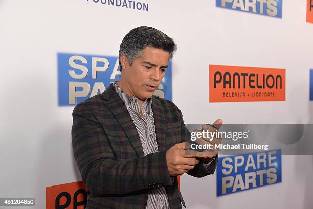 Actor Esai Morales checks his cell phone at the premiere of Pantelion Films' "Spare Parts" at ArcLight Cinemas on January 8, 2015 in Hollywood,...