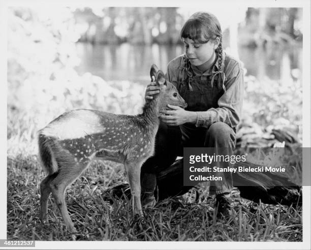 Actress Dana Hill with a fawn, in a scene from the movie 'Cross Creek', 1983.