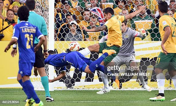 Ali Hussain Fadhel of Kuwait dives and heads home a goal as Australia's Tim Cahill and Mathew Ryan attempt to block during the opening football match...