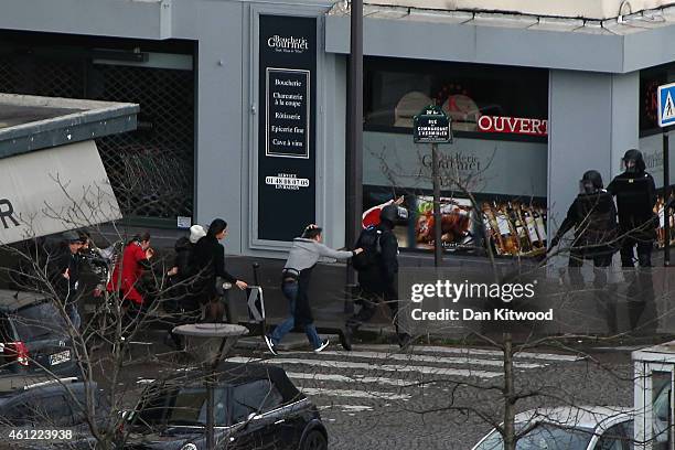 People are led away from the scene as Police mobilize with reports of a hostage situation at Port de Vincennes on January 9, 2015 in Paris, France....
