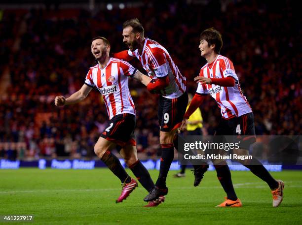 Phil Bardsley of Sunderland celebrates with team mates Steven Fletcher and Ki Sung-Yong as Ryan Giggs of Manchester United scores an own goal during...