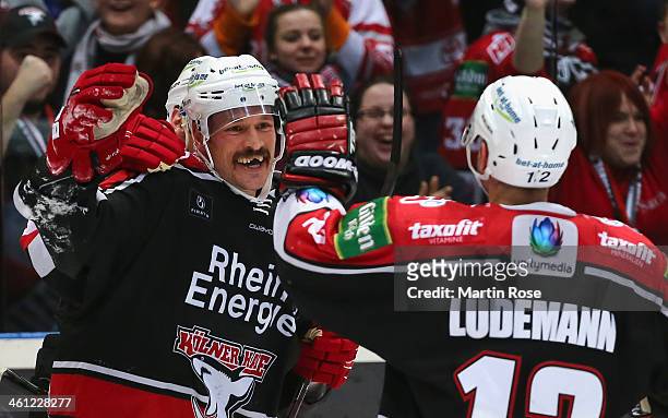 John Tripp of Koeln celebrate with team mate Mirko Luedemann after he scores his team's winning goal in over time during the DEL match between...