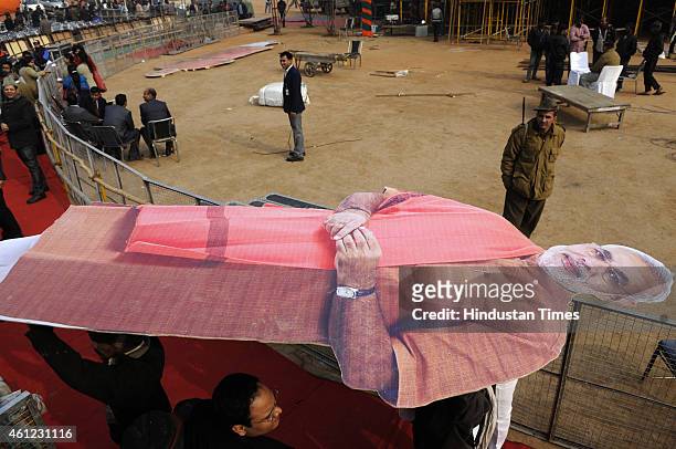 Workers setting up a large cutout of Prime Minister Narendra Modi as the preparations are in full swing for BJP mega rally at Ramlila Maidan on...