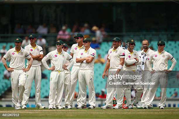 Australian players wait for a decision by the third umpire on a stumping by Brad Haddin of Australia during day five of the Fourth Test match between...