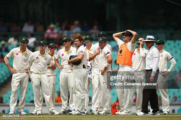 Australian players wait for a decision by the third umpire on a stumping by Brad Haddin of Australia during day five of the Fourth Test match between...