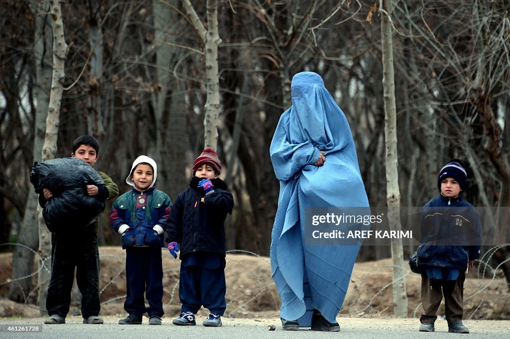 An Afghan Burqa clad Woman Stands With Her Children On A Street In an-afghan-burqa-clad-woman-stands-with-her-children-on-a-street-in