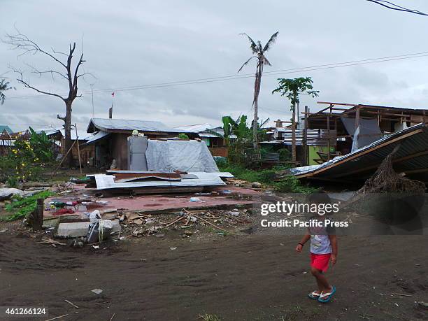 Young girl passing at a heavily damaged house by Typhoon Yolanda and Typhoon Ruby in San Jose, Tacloban City.