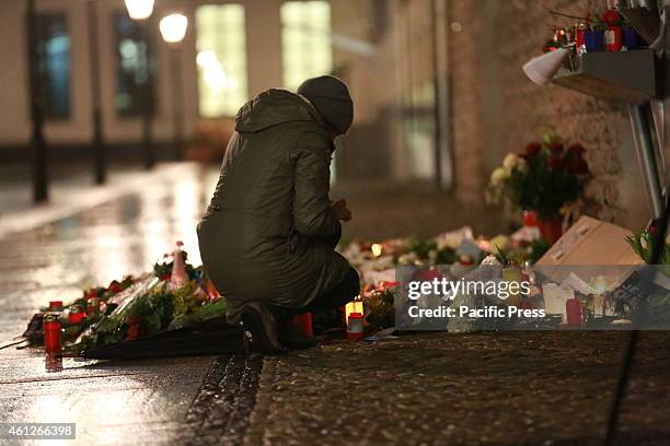 People lay flowers and candles infront of the French Embassy for the victims of the Charlie Hebdo massacre in Paris.