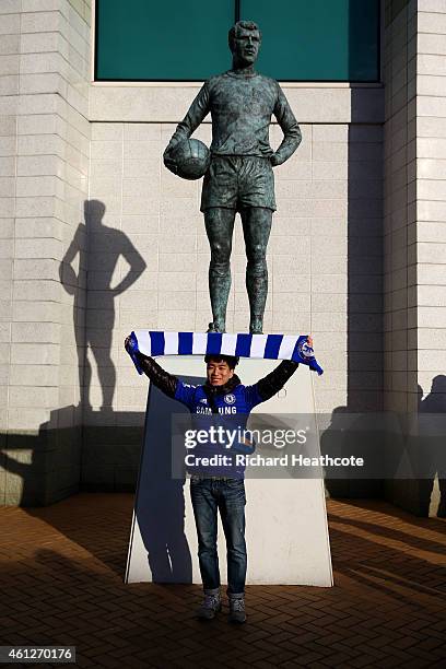 Chelsea fan poses next to the Peter Osgood statue outside the stadium before the Barclays Premier League match between Chelsea and Newcastle United...