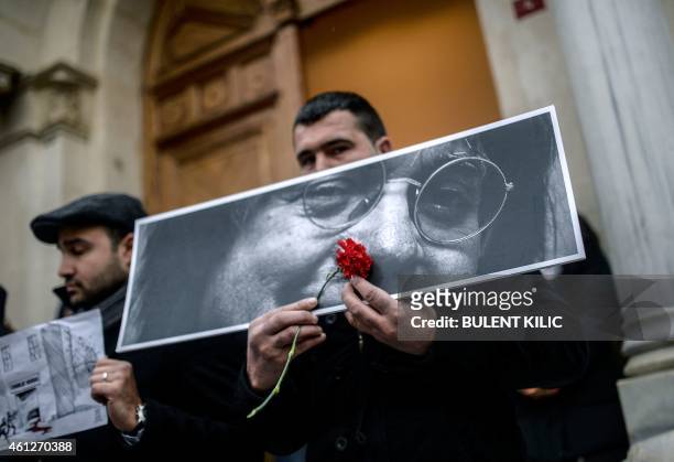 Man holds a picture of French late Jean Cabut, aka Cabu, during a rally in front of the French consulate on January 10 in Istanbul. Tens of thousands...