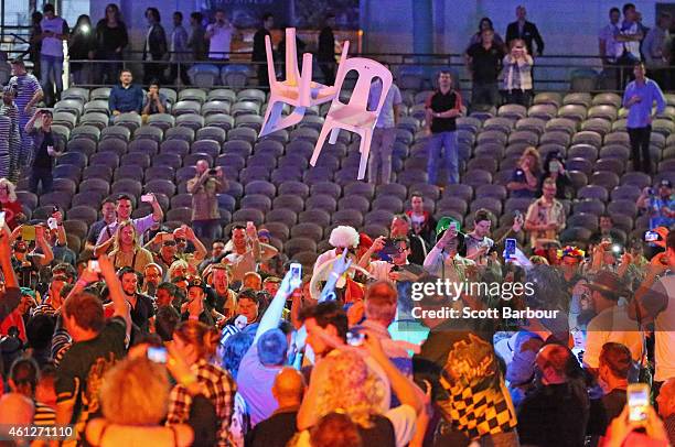 Spectators throw chairs and tables during the final between Simon The Wizard Whitlock and Mighty Michael van Gerwen during the Invitational Darts...