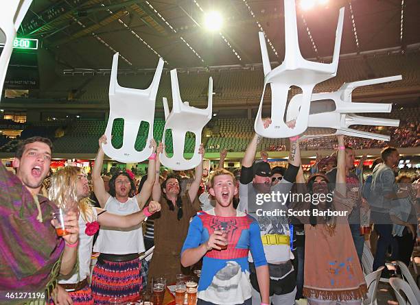 Fans in fancy dress raise chairs above their heads during the Invitational Darts Challenge at Etihad Stadium on January 10, 2015 in Melbourne,...