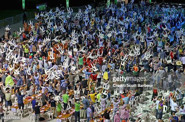 Fans in fancy dress raise chairs above their heads during the Invitational Darts Challenge at Etihad Stadium on January 10, 2015 in Melbourne,...