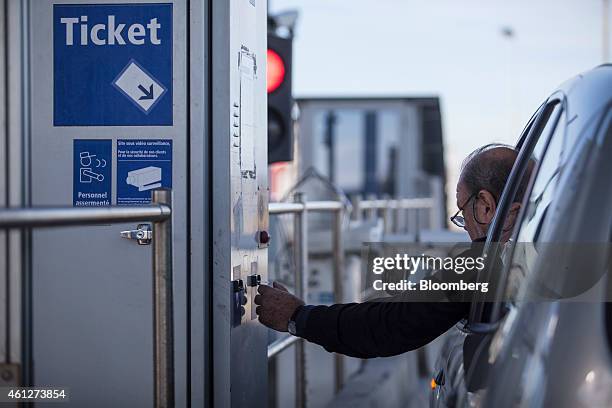 Motorist collects a ticket at the toll booth, operated by Autoroutes du Sud de la France , a division of Vinci SA, as they enter the A61 motorway in...