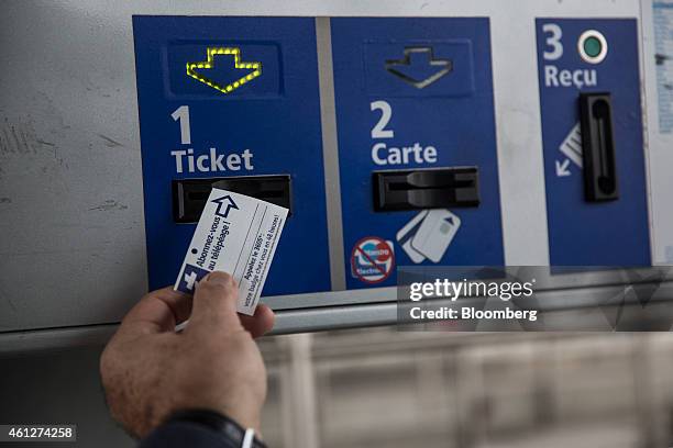 Motorist collects a ticket at the toll-booth as they enter the A61 motorway, operated by Autoroutes du Sud de la France , a division of Vinci SA,...