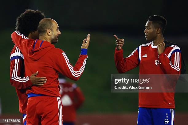 Head coach Pep Guardiola talks to Dante and David Alaba during day 2 of the Bayern Muenchen training camp at ASPIRE Academy for Sports Excellence on...