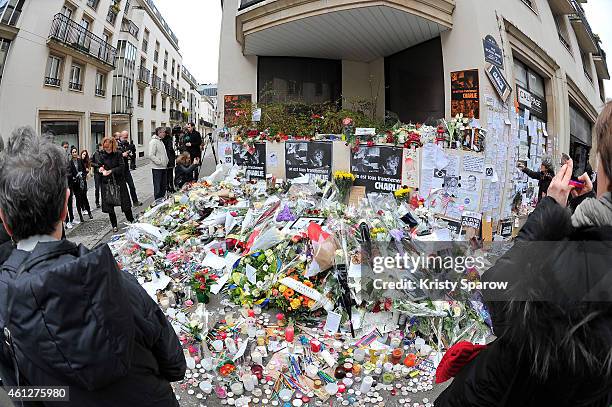 General view outside the French satirical magazine Charlie Hebdo where people arrived to pay their respects placing flowers, pens and drawings on...