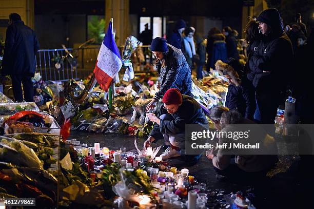 Members of public the light candles in tribute near the offices of French satirical magazine Charlie Hebdo on January 10, 2015 in Paris, France. Four...