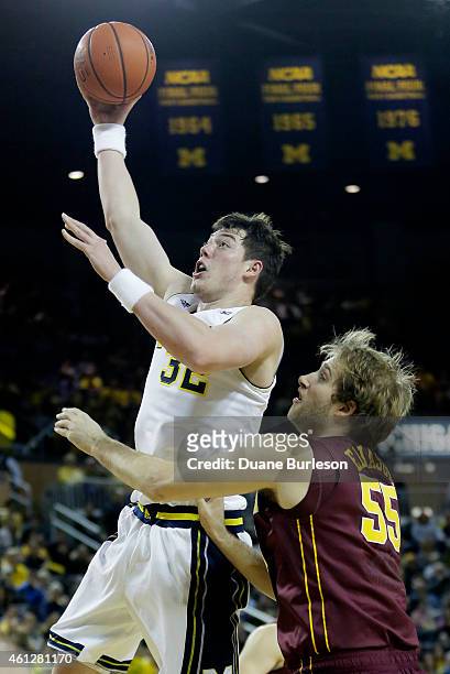 Ricky Doyle of the Michigan Wolverines goes to the basket past Elliott Eliason of the Minnesota Golden Gophers during the first half at Crisler Arena...