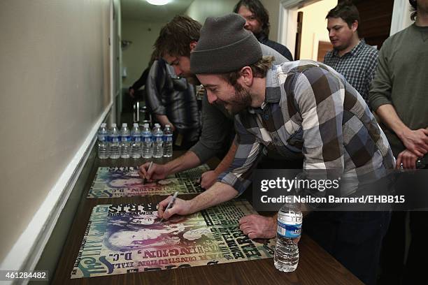 Dave Carroll and Dave Simonett signs a poster at The Life & Songs of Emmylou Harris: An All Star Concert Celebration at DAR Constitution Hall on...