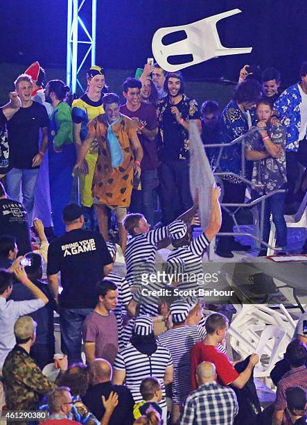 Spectators in fancy dress throw chairs and tables during the final between Simon The Wizard Whitlock and Mighty Michael van Gerwen during the...