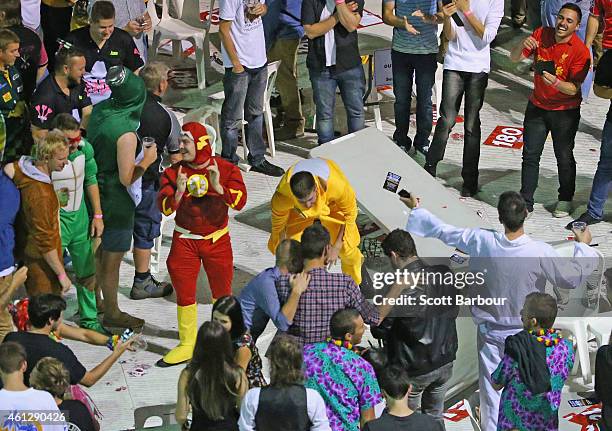 Spectators in fancy dress look on after throwing chairs and tables during the final between Simon The Wizard Whitlock and Mighty Michael van Gerwen...