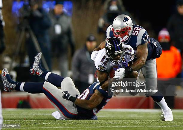 Jacoby Jones of the Baltimore Ravens makes a catch against Brandon Bolden and Jonathan Casillas of the New England Patriots in the second quarter...