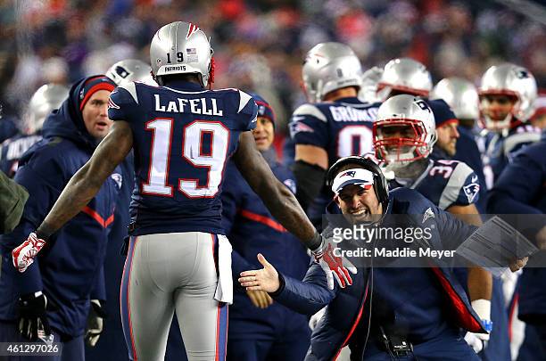 Brandon LaFell of the New England Patriots high fives offensive coordinator Josh McDaniels after catching a touchdown pass during the fourth quarter...