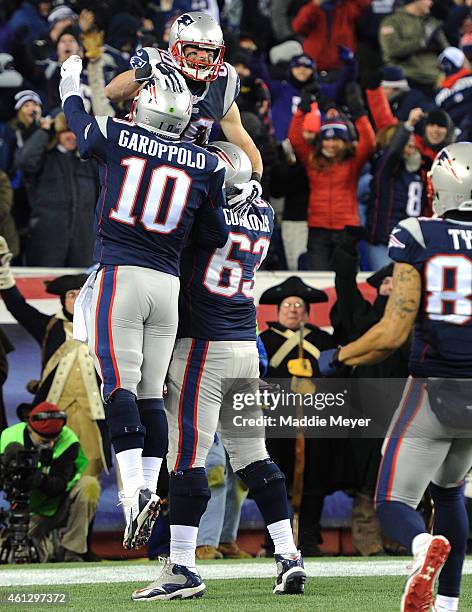 Julian Edelman of the New England Patriots reacts alongside Jimmy Garoppolo and Dan Connolly after Edelman caught a touchdown pass during the second...
