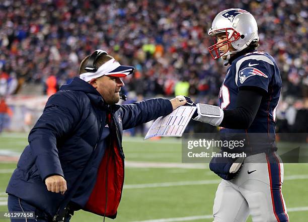 Tom Brady of the New England Patriots high fives Offensive Coordinator Josh McDaniels after throwing a touchdown pass during the fourth quarter of...