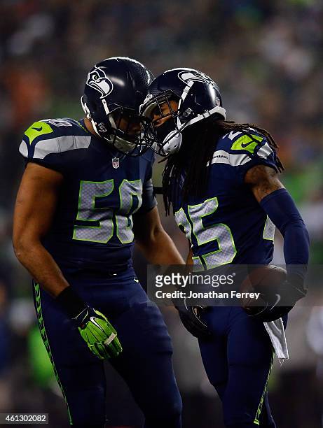 Richard Sherman of the Seattle Seahawks celebrates with K.J. Wright after intercepting a ball intended for Philly Brown of the Carolina Panthers...
