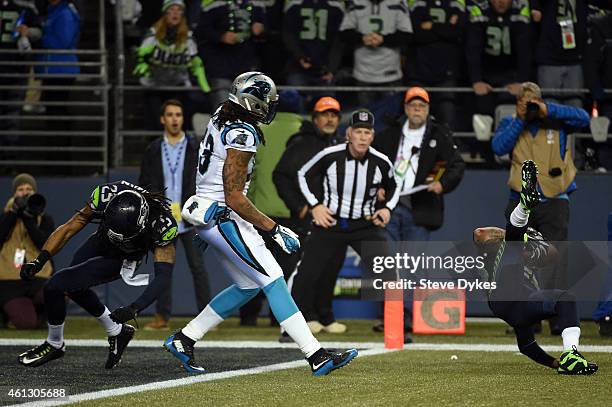 Earl Thomas of the Seattle Seahawks attemps to intercept a pass intended for Kelvin Benjamin of the Carolina Panthers thrown by Cam Newton that was...