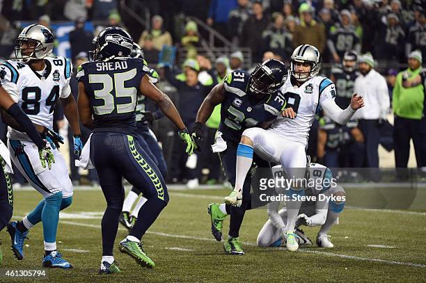 Kam Chancellor of the Seattle Seahawks runs into Graham Gano of the Carolina Panthers after blocking a field goal attempt at the and of the second...