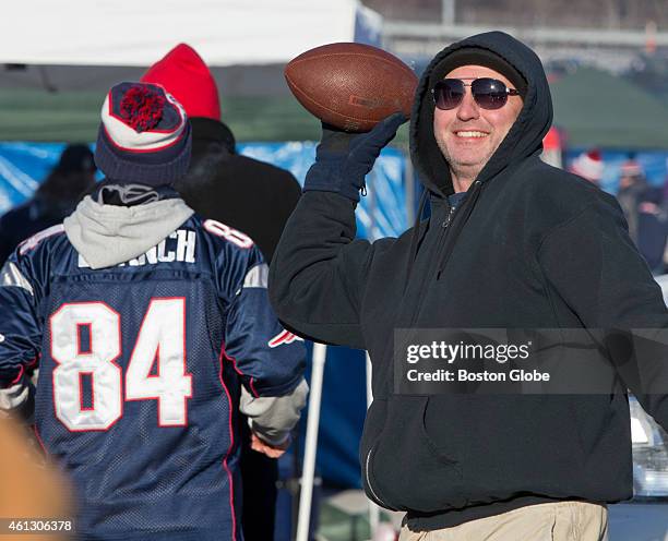 Scott Travers, of Fall River, Mass., throws the football as he tailgates before the New England Patriots play the Baltimore Ravens during the AFC...