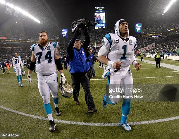 Cam Newton of the Carolina Panthers runs off the field after being defeated by the Seattle Seahawks in the 2015 NFC Divisional Playoff game at...