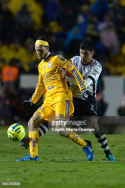 Enrique Perez of Atlas tries to take the ball from Edgar Lugo of Tigres during a match between Tigres UANL and Atlas as part of 1st round Clausura...