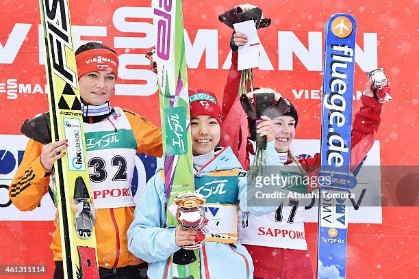 Second place Carina Vogt of Germany, first place Sara Takanashi of Japan and third place Chiara Hoelzl of Austria pose in the victory ceremony during...