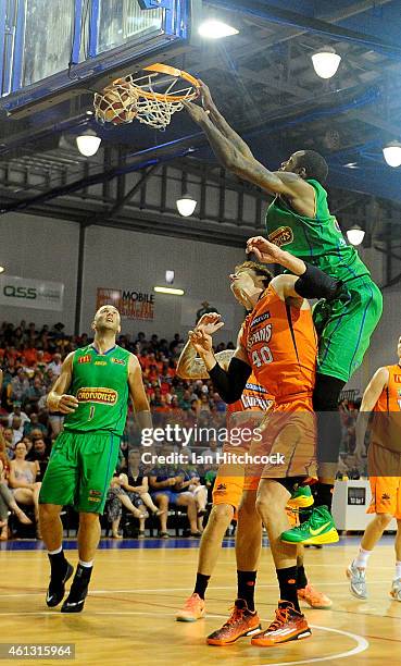 Mickell Gladness of the Crocodiles slam dunks the ball over Alex Loughton of the Taipans during the round 14 NBL match between the Townsville...