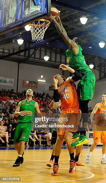 Mickell Gladness of the Crocodiles slam dunks the ball over Alex Loughton of the Taipans during the round 14 NBL match between the Townsville...