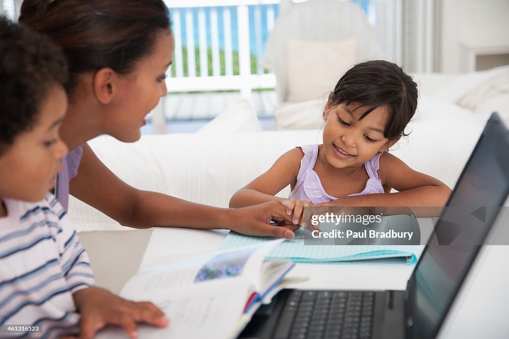 Mother and two kids using laptop