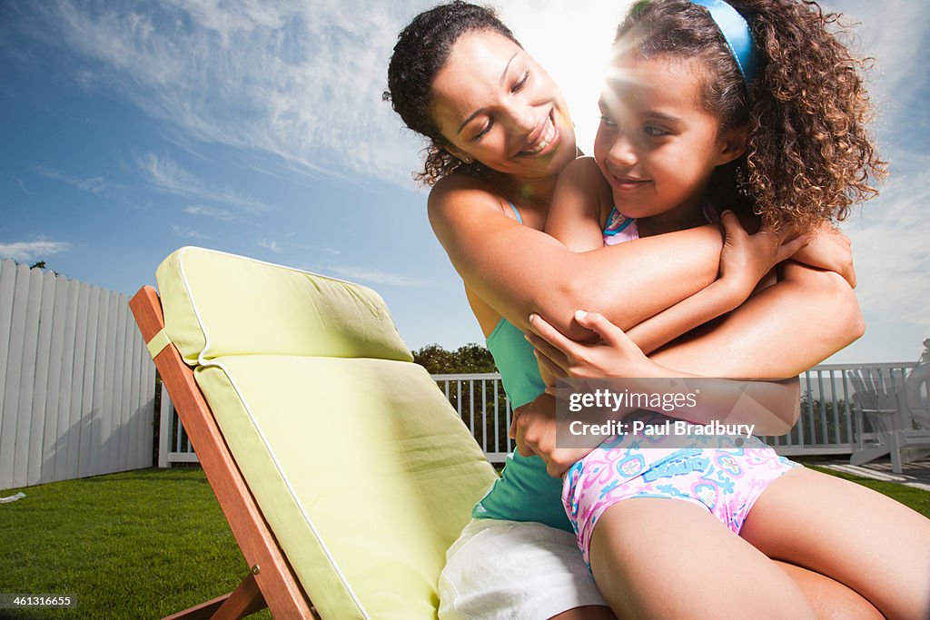 Woman and girl in swimsuit playing outdoors