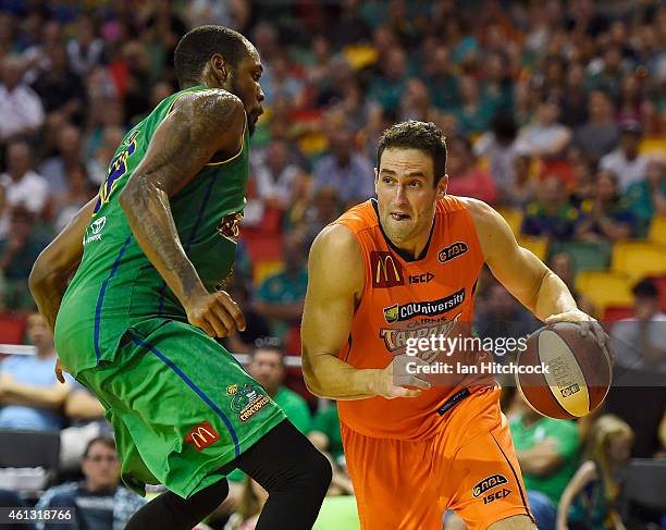 Matthew Burston of the Taipans drives to the basket past Mickell Gladness of the Crocodiles during the round 14 NBL match between the Townsville...