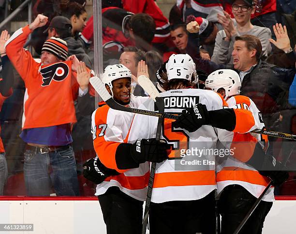 Brayden Schenn of the Philadelphia Flyers is congratulated by teammates Wayne Simmonds and Braydon Coburn after Schenn scored the game winner in...