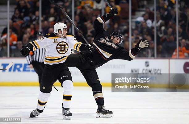 Adam McQuaid of the Boston Bruins checks Patrick Maroon of the Anaheim Ducks in the first period at Honda Center on January 7, 2014 in Anaheim,...