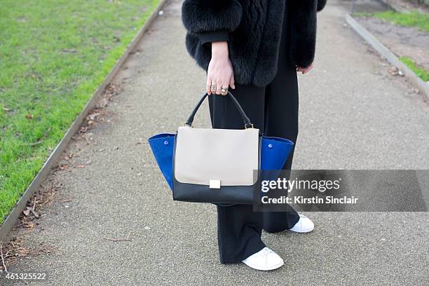 Fashion blogger Zena Charkoplia wearing her own design coat, Celine bag and Zara jumpsuit on day 2 of London Collections: Men on January 10, 2015 in...